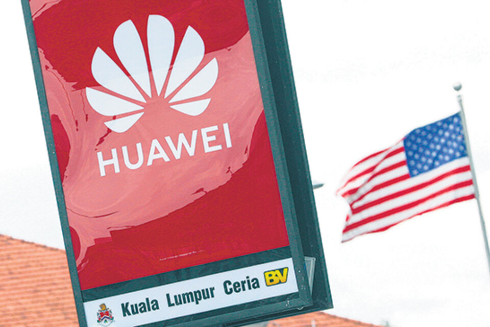 El logo de Huawei desplegado frente a la bandera estadounidense en Kuala Lumpur, Malasia.