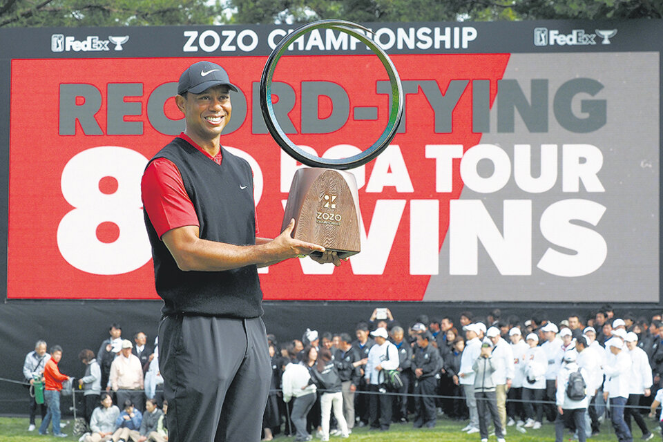 Tiger Woods levanta el trofeo 82 de su carrera, con el que igualó la marca de Sam Snead. (Fuente: AFP)