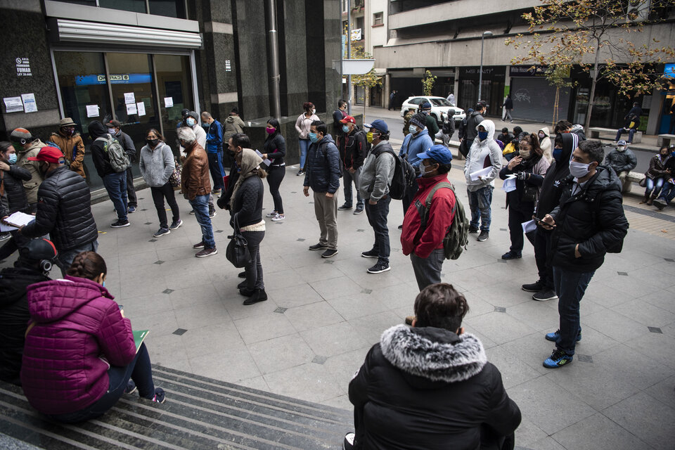 Cola con distanciamiento social frente a una oficina de desempleo en Santiago. (Fuente: AFP)