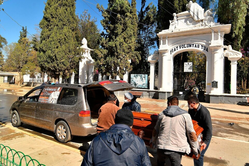 Los familiares retiran el féretro de un pariente de las puertas del cementerio de Cochabamba, donde no tienen cupo para enterrarlo. (Fuente: EFE)
