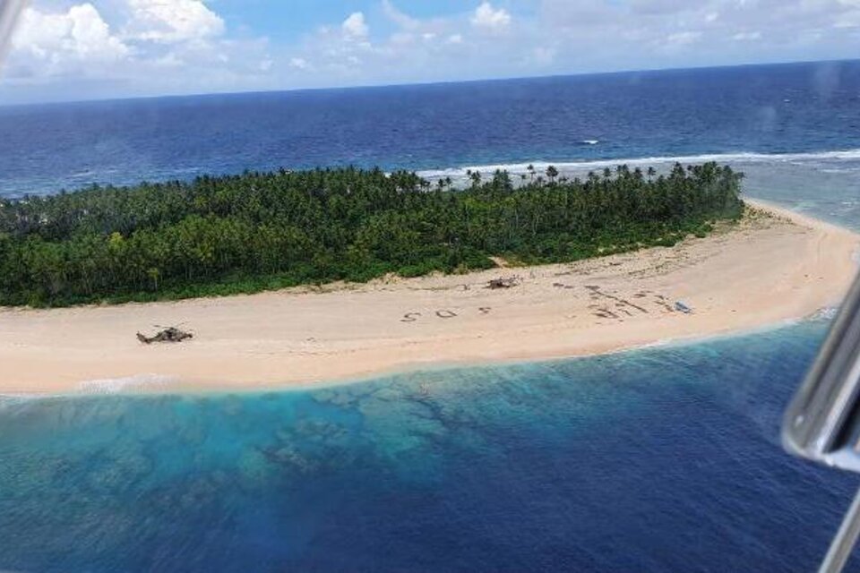 Vista área de la pequeña isla de Micronesia donde quedaron varados los tres hombres y el SOS en la arena. 