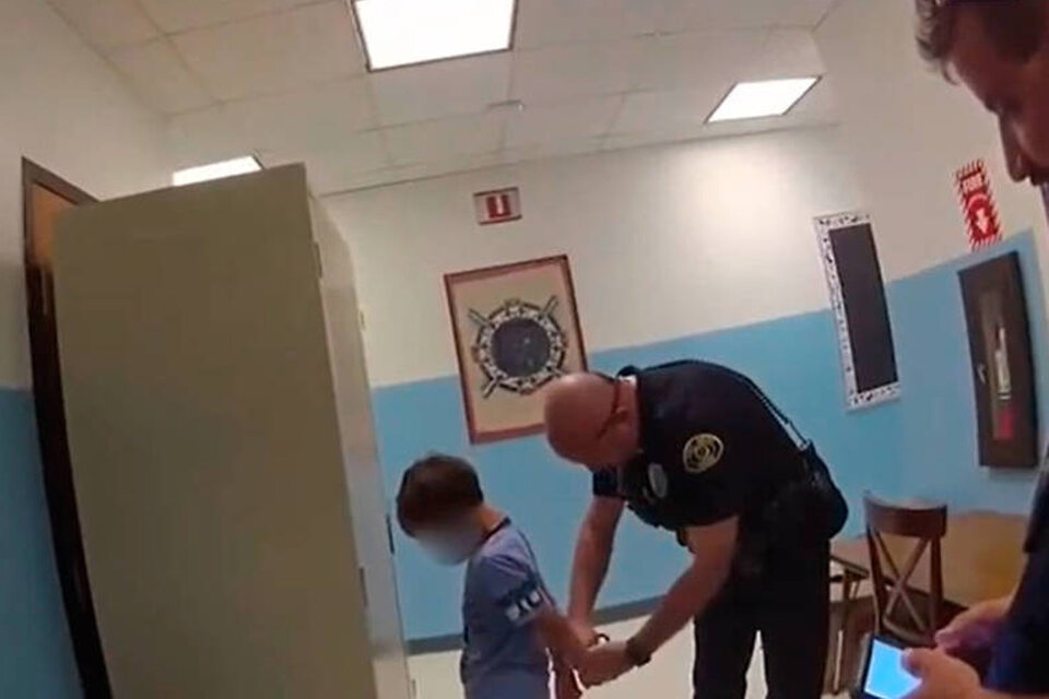 Captura de pantalla del video que muestra al policía esposando al niño.