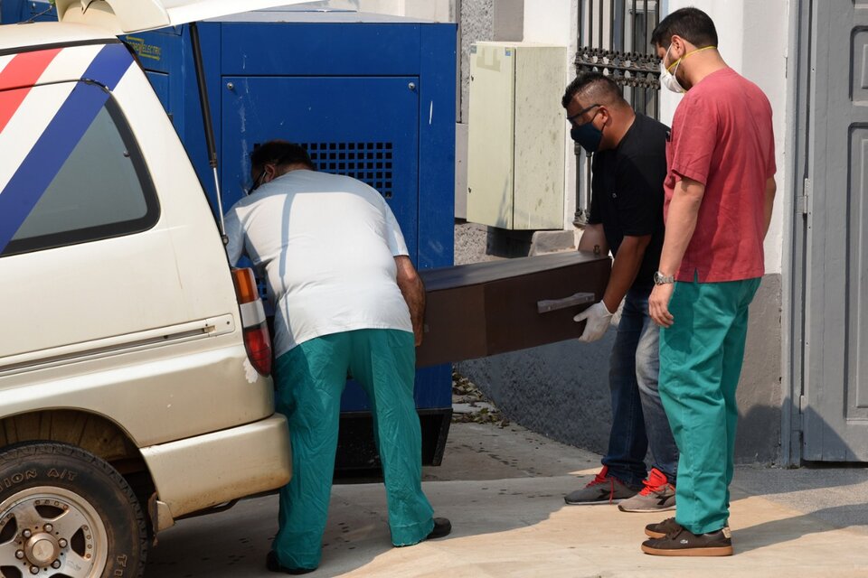 Empleados de la oficina forense cargan el cajón de una de las niñas en la morgue judicial. (Fuente: AFP)