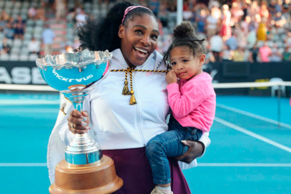 Serena Williams con un trofeo en un brazo y su hija Olympia en el otro. (Fuente: AFP)