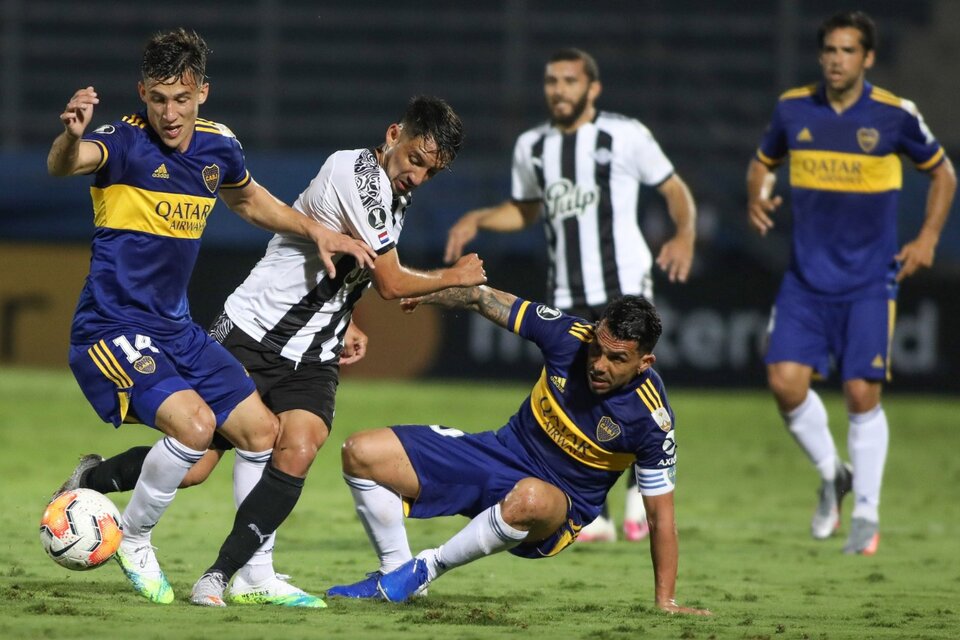 Capaldo y Tevez luchan por la pelota en la ida ante Libertad: fue 2-0 en Asunción. (Fuente: Fotobaires)