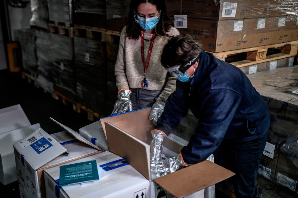Trabajadores de  salud abren las primeras cajas de vacunas Pfizer en una farmacia mayorista cerca de París (Fuente: EFE)