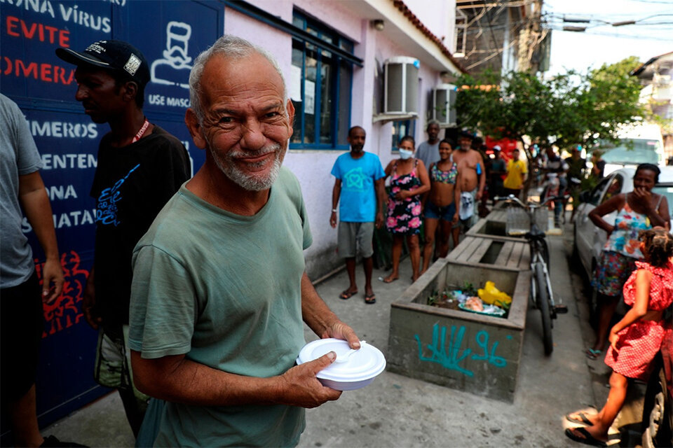 Habitantes de la favela da Maré hacen fila para recibir alimentos, en Rio de Janeiro.