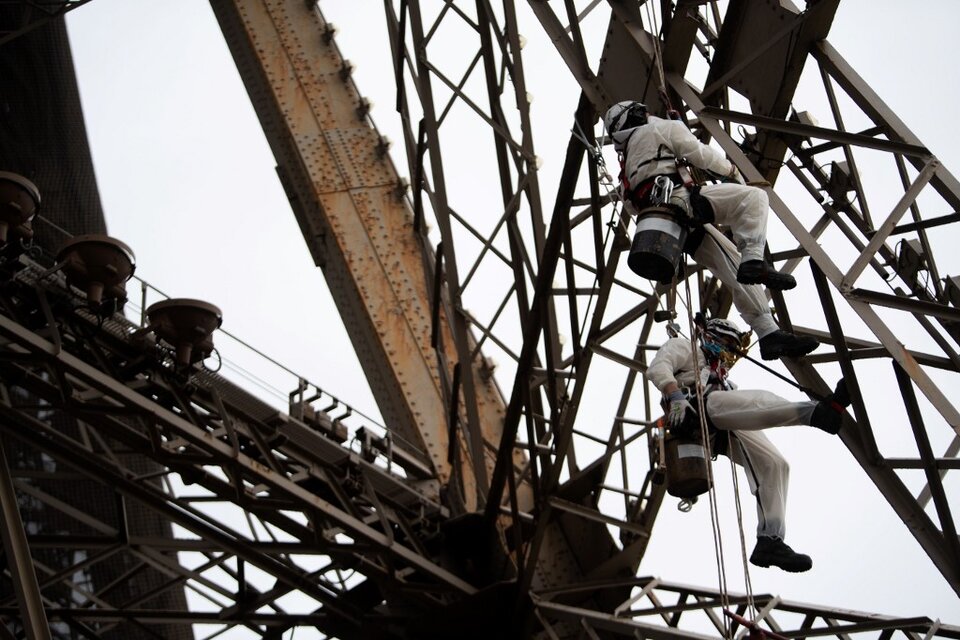 Los pintores que trabajan en altura para repitar la Torre Eiffel. (Fuente: AFP)
