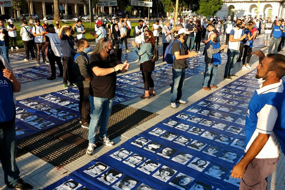 Grupos de 12 personas con la distancia necesaria de dos metros entre cada una sostuvieron los 13 paños con los rostros de los desaparecidos, extendidos desde la Pirámide de Mayo hasta la calle Bolivar. (Fuente: Adrián Pérez)