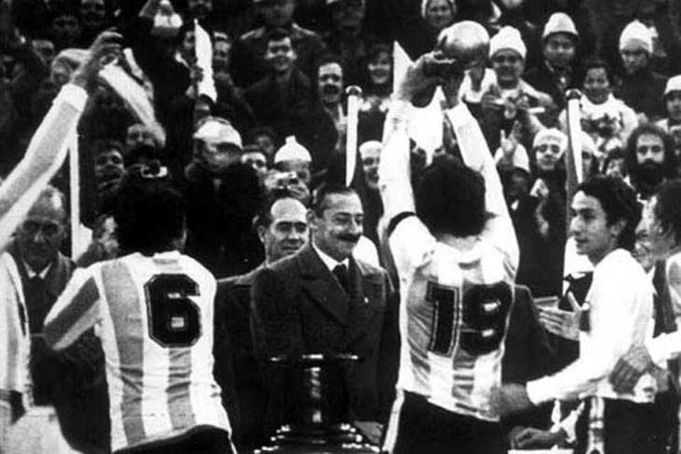 Los campeones reciben la copa de manos de Videla.