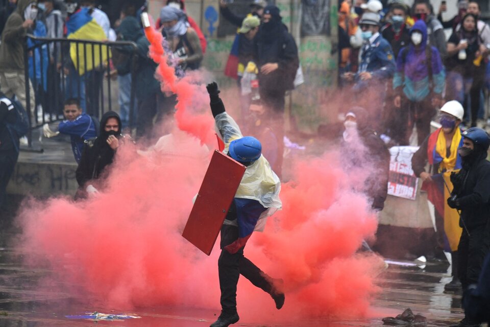 Un manifestante arroja una bomba de humo durante una protesta en Bogotá (Fuente: AFP)