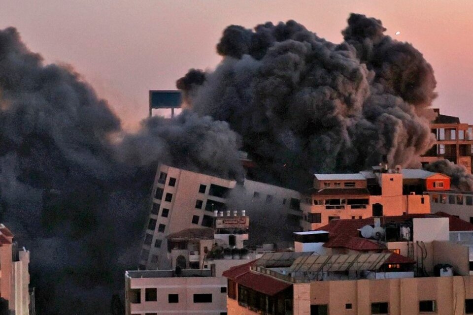 El bombardeo israelí derribó unedificio de 12 pisos en Ciudad de Gaza. Foto2: autos destrozados por un cohete palestino en Holon, cerca de Tel Aviv. Foto3: funeral Gaza de un palestino muerto en elbombardeo israelí (Fuente: AFP)
