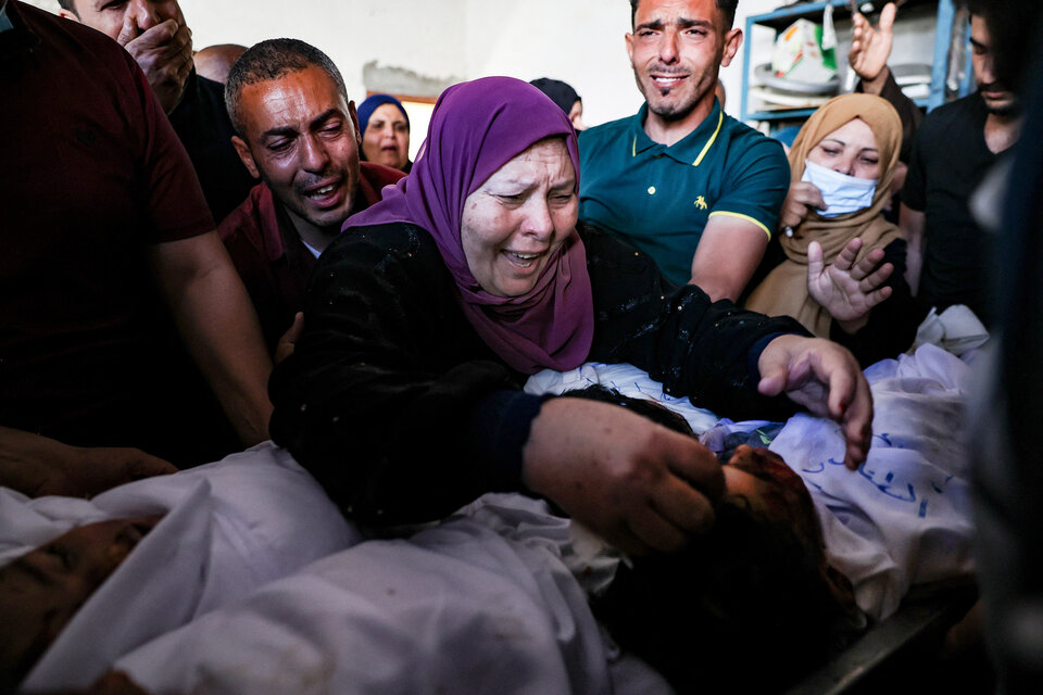 Funeral de los tres niños Al-Tanani muertos en Gaza durante un bombardeo israelí . Foto 2: Daño a un edificio y un auto en Ashkelon causado por un cohete lanzado desde Gaza. (EFE) (Fuente: AFP)