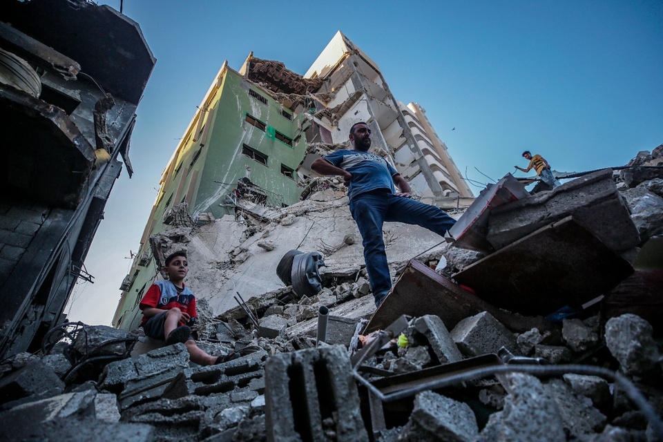 Palestinos caminan sobre los escombros de un edificio destruido en Ciudad de Gaza. (Fuente: AFP)