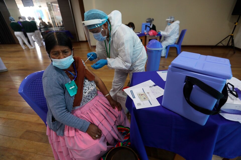 Un funcionario de salud vacuna a una persona en un punto de vacunación masiva contra la covid-19 en Bolivia (Fuente: EFE)