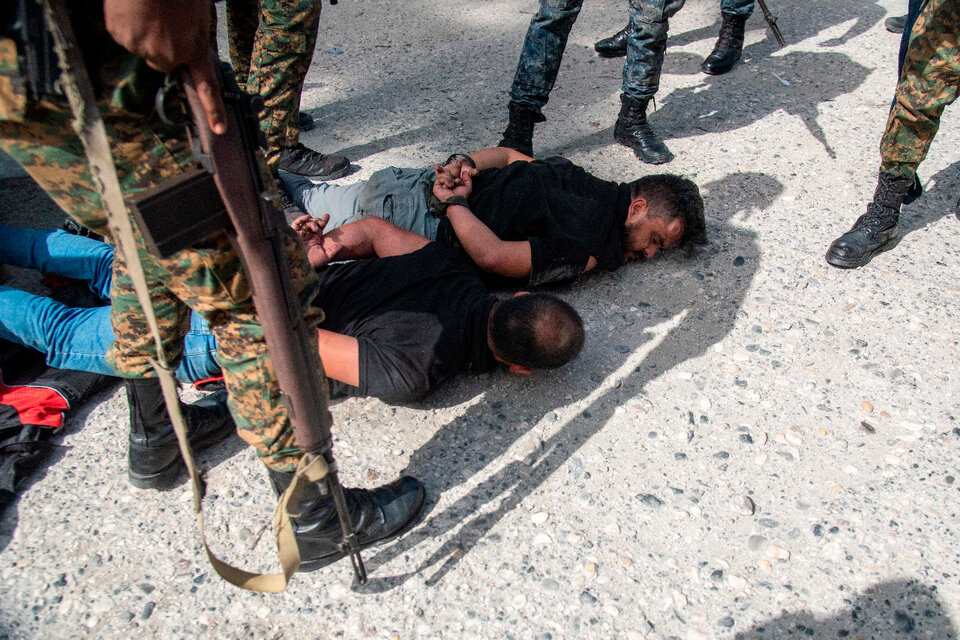 Policías custodian hoy a dos sospechosos de haber participado en el asesinato del presidente haitiano.  (Fuente: EFE)