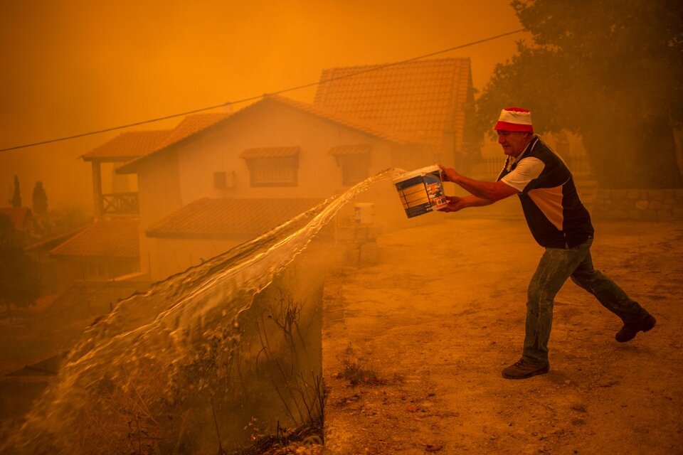 Muchos pobladores de Ellinika no aceptaron dejar sus casas y combaten el fuego por sus propios medios. (Fuente: AFP)