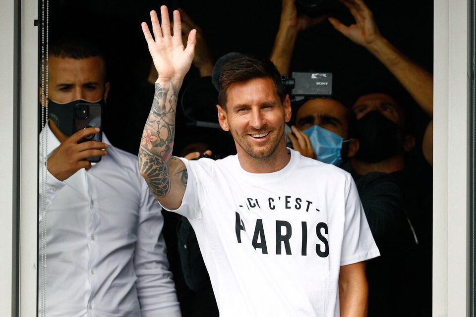 Messi se asomó por una de las ventanas del aeropuerto a saludar vistiendo una remera con la inscripción "Ici c'est Paris" (Esto es París). (Fuente: AFP)