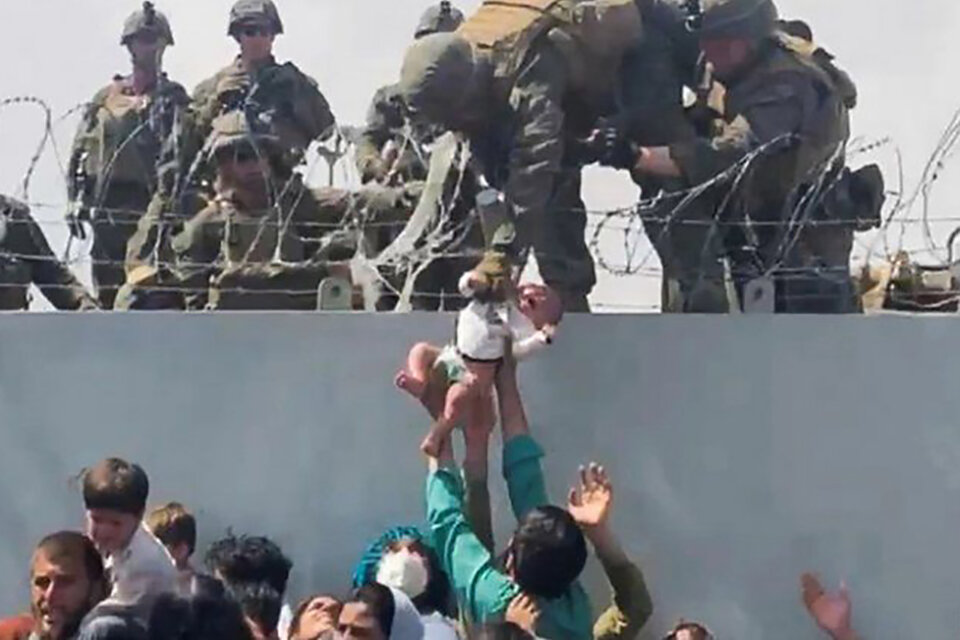 El ejército estadounidense publicó varias fotos que muestran a sus soldados cuidando niños en el aeropuerto Hamid Karzai. (Fuente: Captura de pantalla)