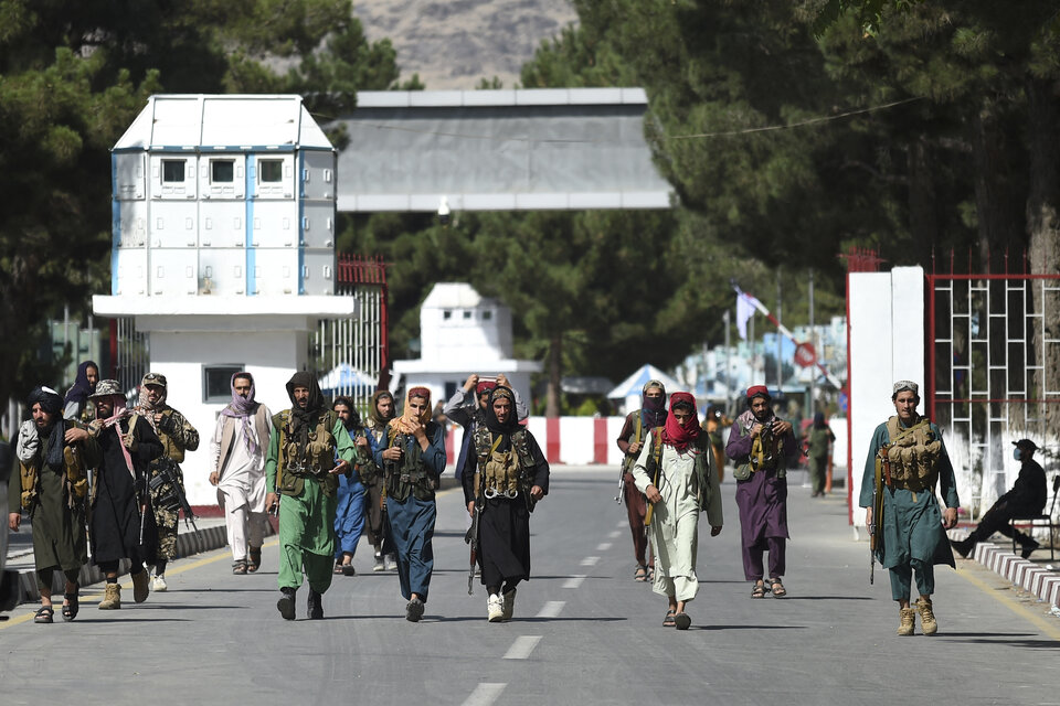 Los talibanes caminan por la puerta de entrada principal del aeropuerto de Kabul. (Fuente: AFP)
