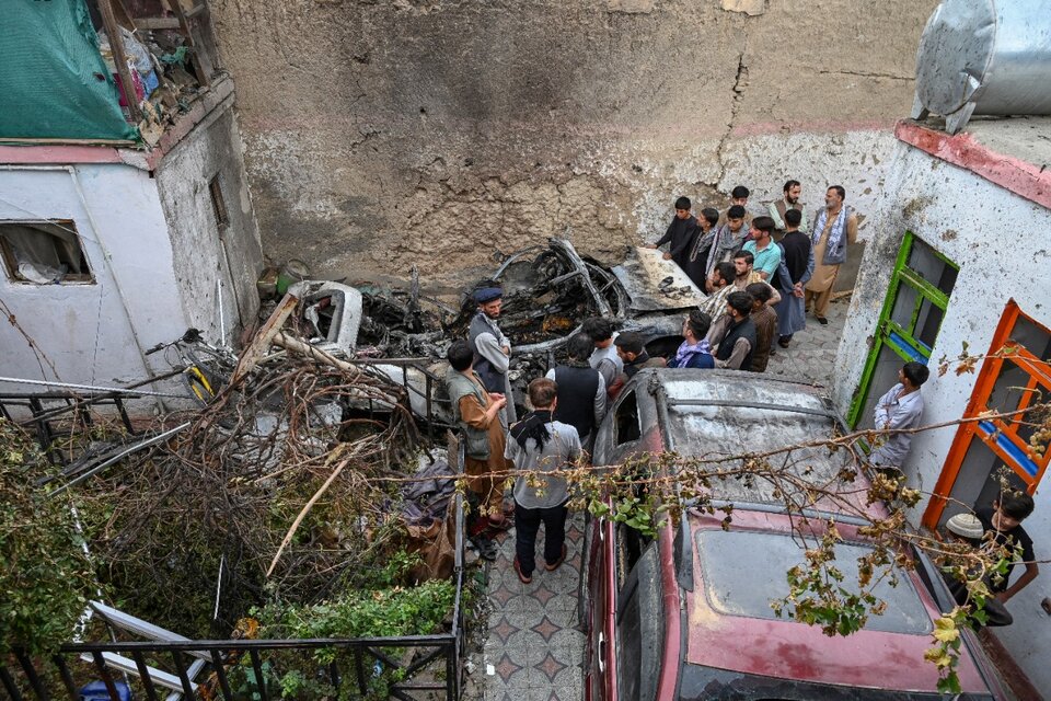 Familiares y vecinos rodean el vehículo destrozado por el dron de EE.UU. en Kabul, (Fuente: AFP)