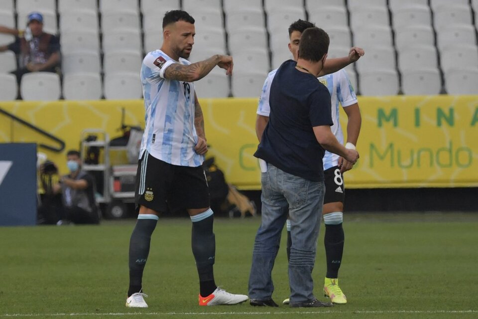 Otamendi y Acuña frente al hombre que interrumpió el partido (Fuente: AFP)