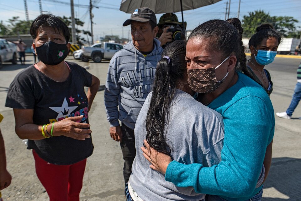 Familiars de detenidos se abrazan después del motín en la entrada a la cárcel de Guayaquil.  (Fuente: AFP)