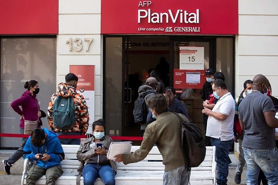 Foto de archivo del 3 de mayo de un grupo de ciudadanos chilenos al hacer fila en la sucursal de una AFP, para realizar el tercer retiro de sus ahorros previsionales, en Santiago de Chile (Fuente: EFE)
