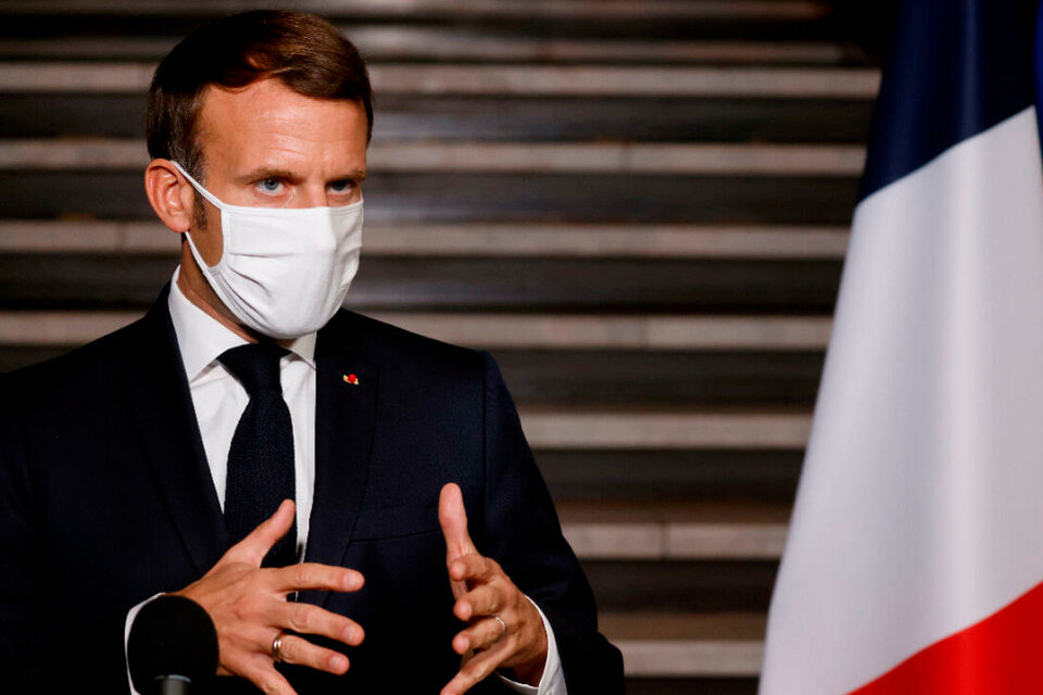 Macron junto a la bandera de Francia con el azul más oscuro.  (Fuente: AFP)