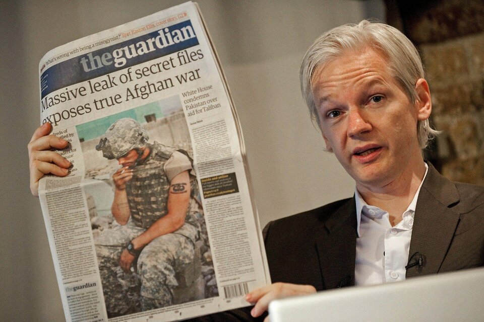 Assange muestra sus revelaciones en la tapa de The Guardian el julio del 2010. (Fuente: AFP)