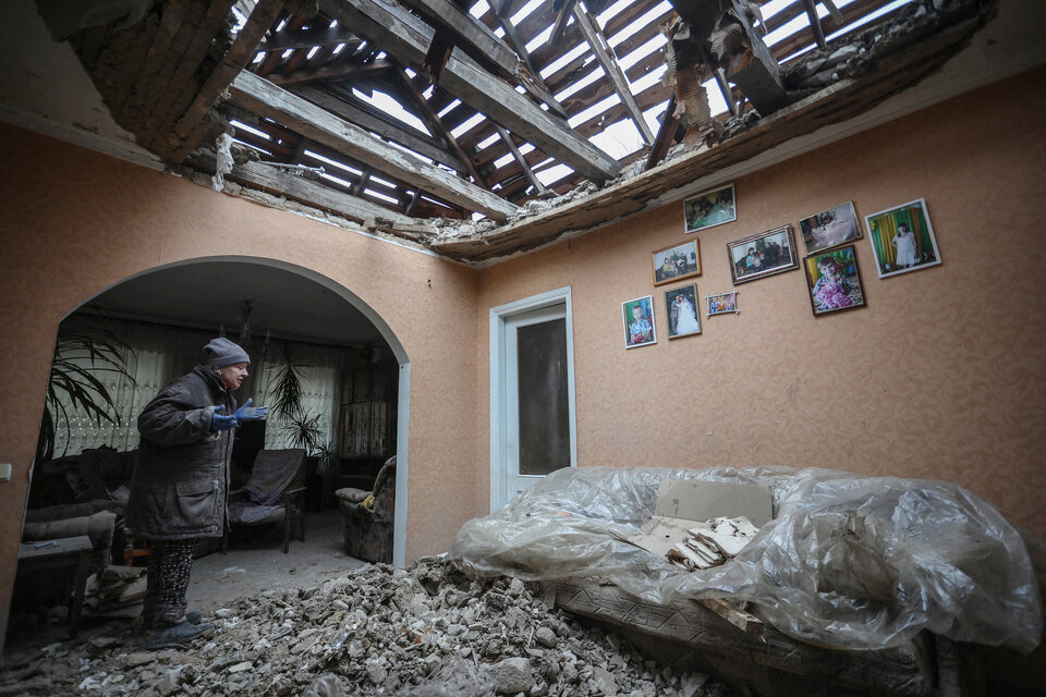 Una mujer intenta limpiar los escombros de su casa tras un bombardeo en Lugansk, Ucrania.  (Fuente: AFP)
