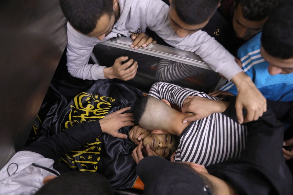 Varios palestinos lloran sobre el cadáver de uno de los dos palestinos asesinado por tropas israelíes en el campo de refugiados de Jenín, Cisjordania, este jueves. (Fuente: EFE)