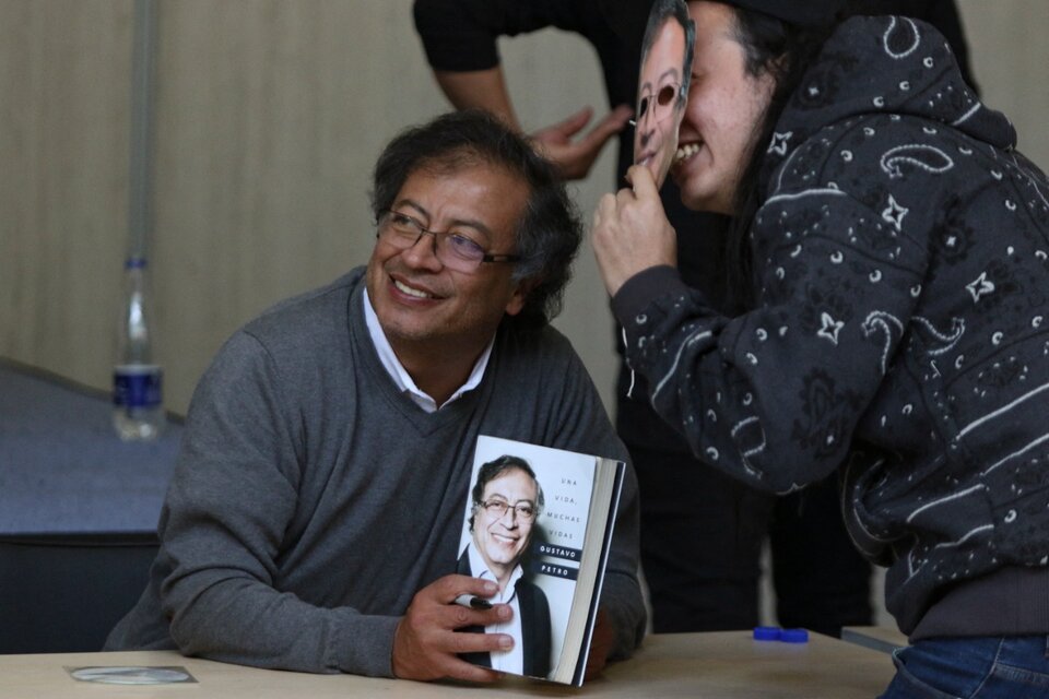 Gustavo Petro sonríe junto a un simpatizante en la Feria del Libro de Bogotá. (Fuente: AFP)