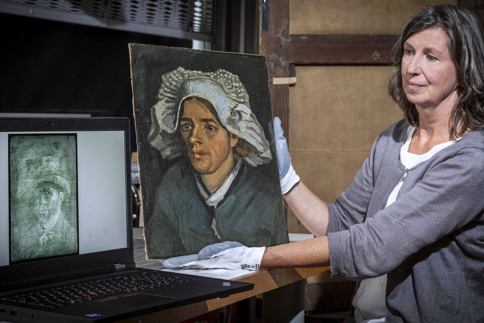 Conservadora de la Galería Nacional de Escocia muestra la pintura "Retrato de una campesina", mientras que en la computadora se ve la radiografía del autorretrato de Van Gogh. (Fuente: EFE)