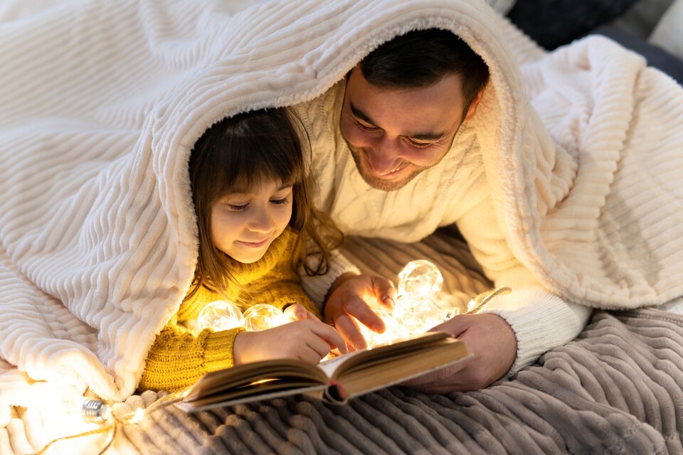 Una manta y una linterna se convierten en un refugio ideal para leer en los días de lluvia. Imagen: Freepik