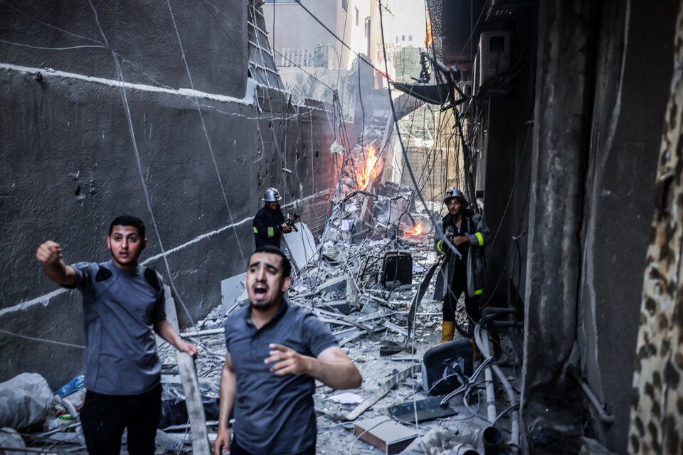 Bomberos y rescatistas en Ciudad de Gaza tras el bombardeo israelí. (Fuente: AFP)