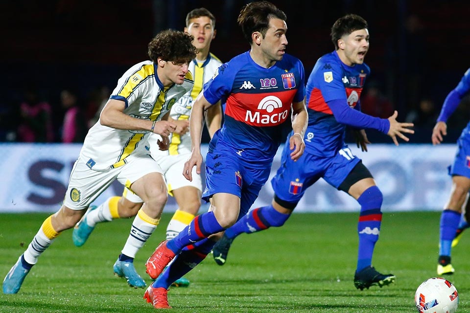 1) Tanlongo persigue a jugadores de Tigre. 2) Almada lucha por la pelota. (Fuente: Fotobaires)