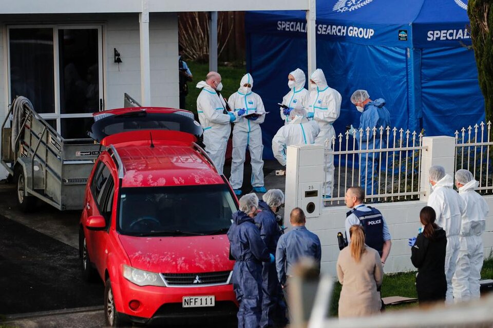 Peritos forenses investigan la casa de la familia neozelandesa que halló los restos de los menores en unas valijas. (Associated Press)