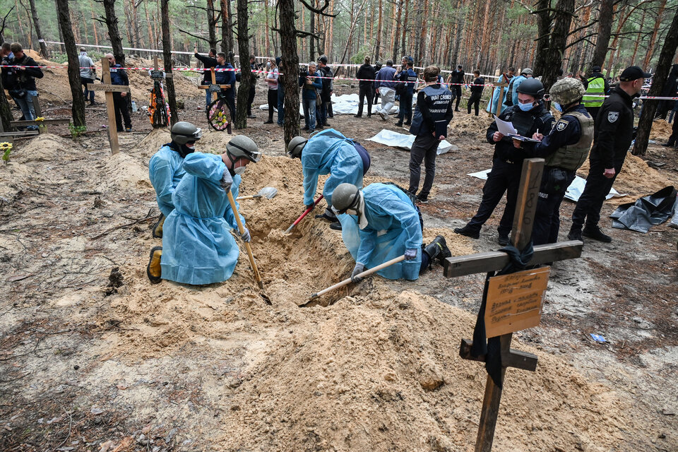 Forenses ucranianos buscan restos cerca de la fosa comúnhallada en Izium. (Fuente: AFP)