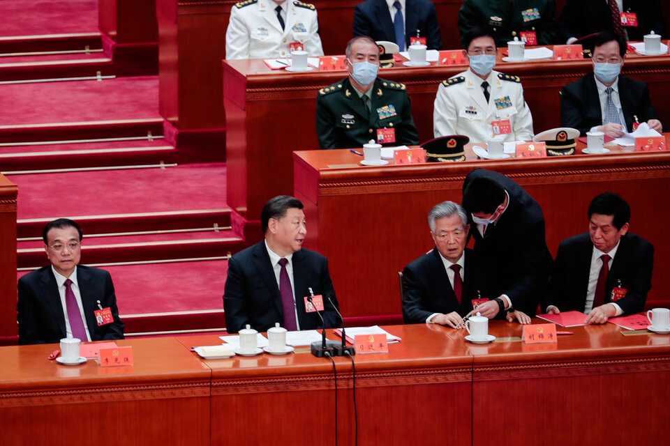 Momento en que Hu Jintao es conminado a dejar la sala, ante la mirada de Xi Jinping.  (Fuente: EFE)