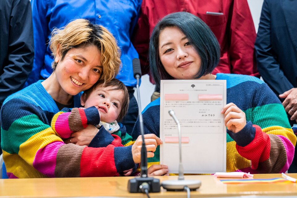 Dos mujeres junto su hijo enseñan su nuevo certificado de pareja del mismo sexo emitido en Tokio. (AFP)
