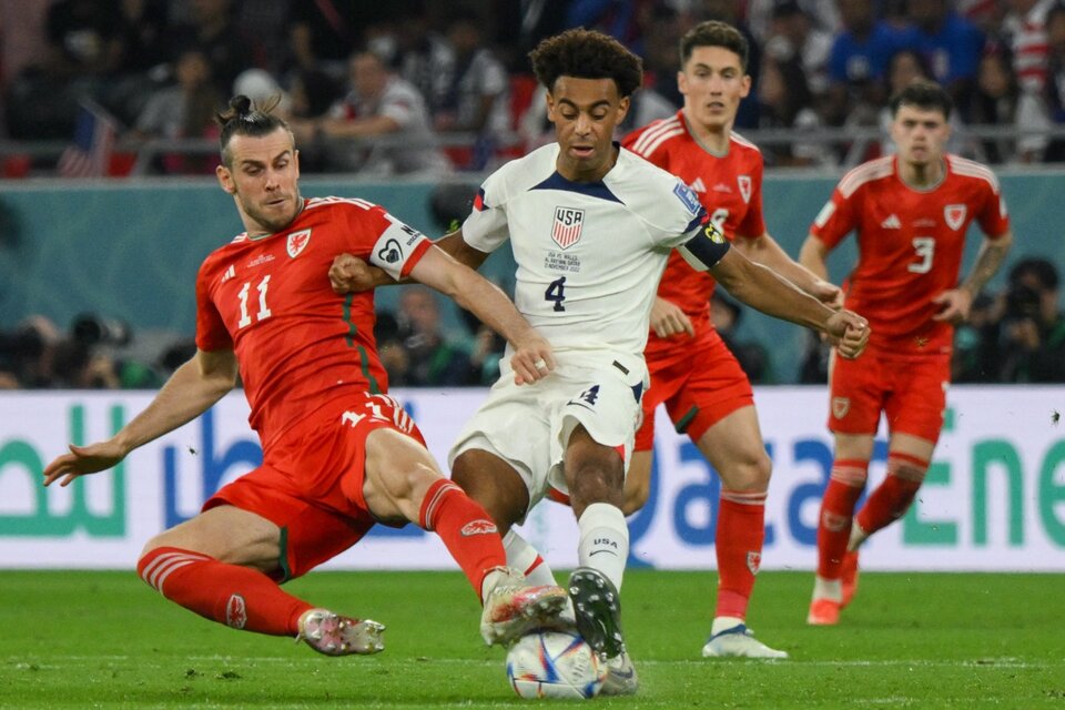 Gareth Bale, que marcó la igualdad, deja todo en la disputa del balón contra el capitán yanqui Tyler Adams (Fuente: AFP)