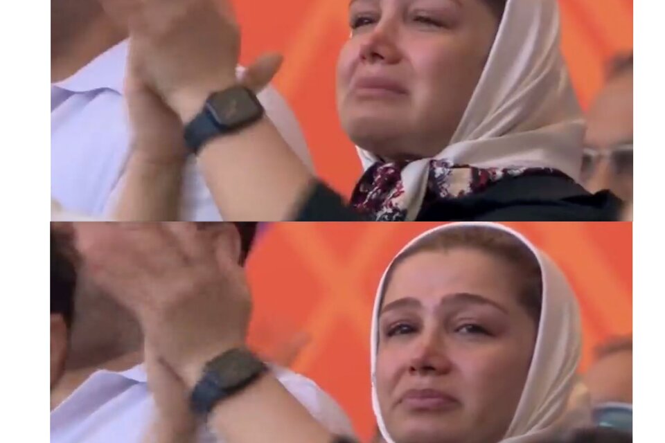 Una mujer de hijab blanco llora emocionada en el primer partido de Irán, cuando los jugadores no cantaron el himno.