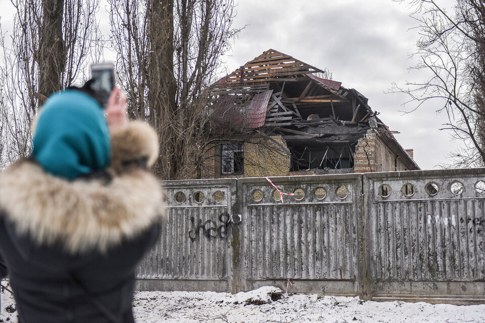 Una mujer le saca una foto en Kiev  a uno de las residencias dañadas por un dron. (Fuente: EFE)