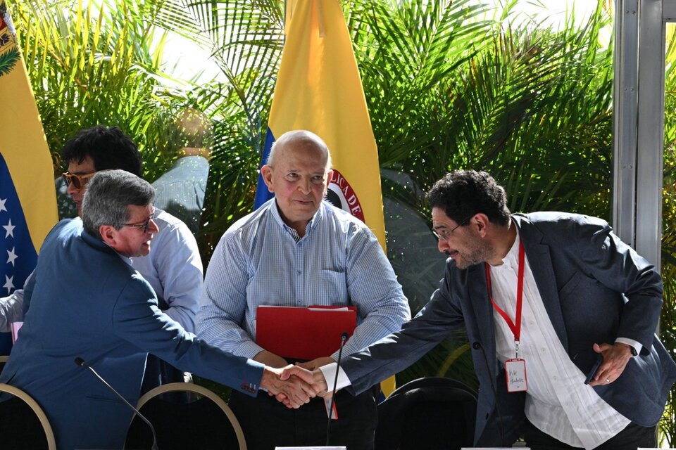 El comandante Pablo Beltrán e Iván Cepeda por el gobierno, se saludan. (Fuente: AFP)