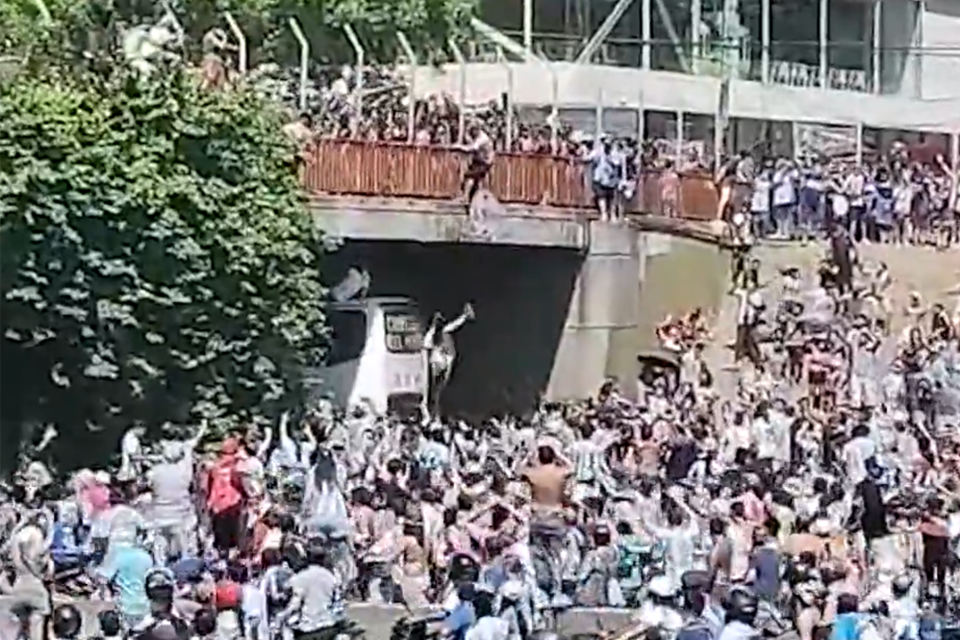 Dos hinchas se tiraron arriba de la caravana de la Selección desde un puente. Imagen: captura de video  