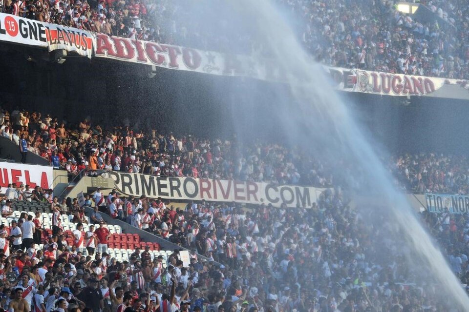 Bomberos tiran agua a las tribunas y plateas del Más Monumental de Nuñez, el domingo durante el partido River-Argentino Jrs. (Foto: Telam).