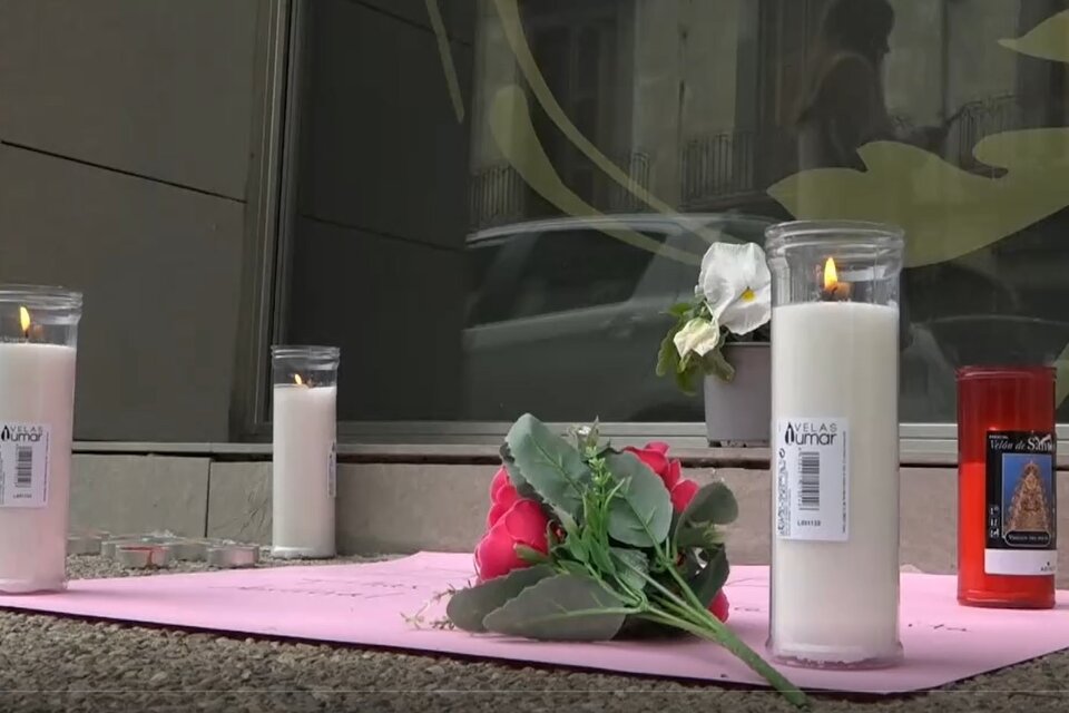 Velas y flores en el edificio de Barcelona donde ocurrió la tragedia. Una de las gemelas murió y la otra permece internada en grave estado. Imagen: Captura de video EFE.