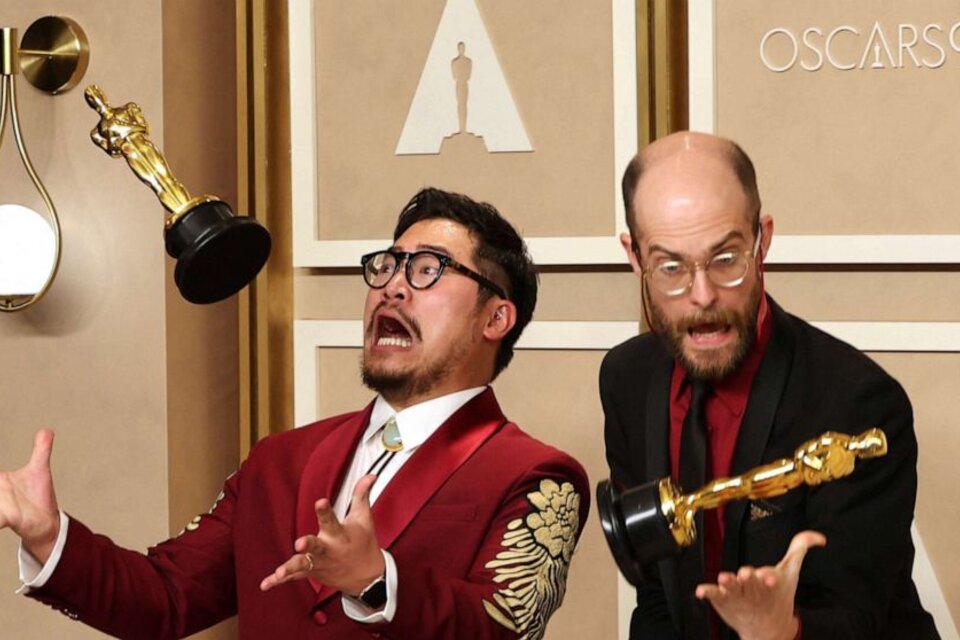 Daniel Kwan y Daniel Scheinert, anoche, revoleando sus Oscar por el aire.   (Fuente: AFP)