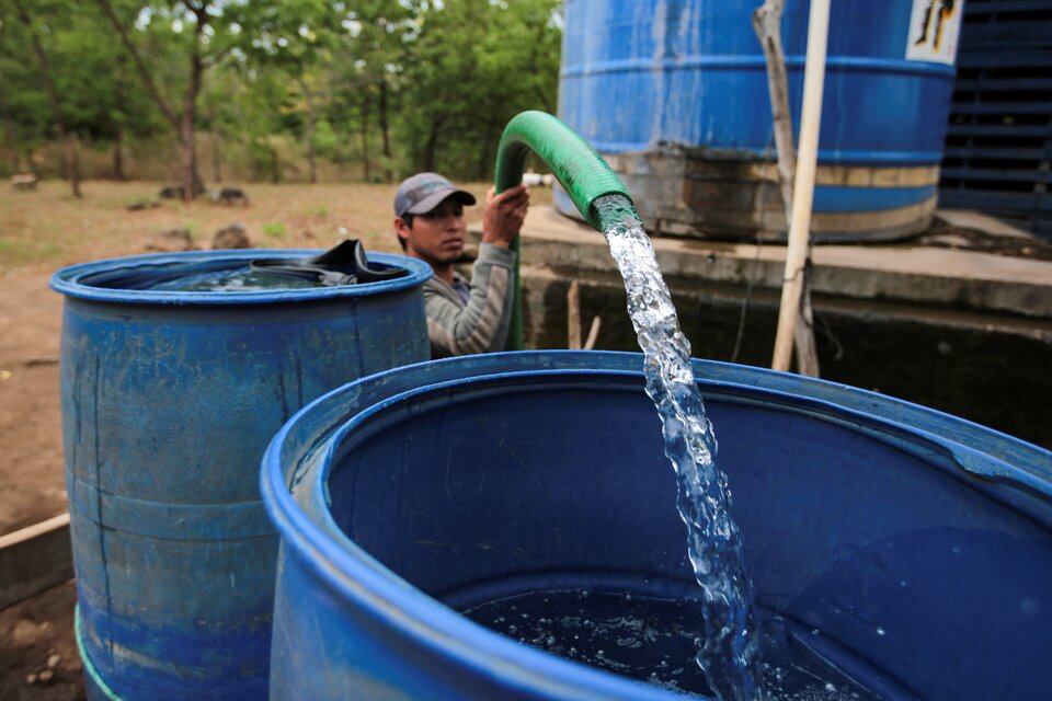 Un hombre retira agua de un pozo público en Managua, Nicaragua (Foto: AFP).